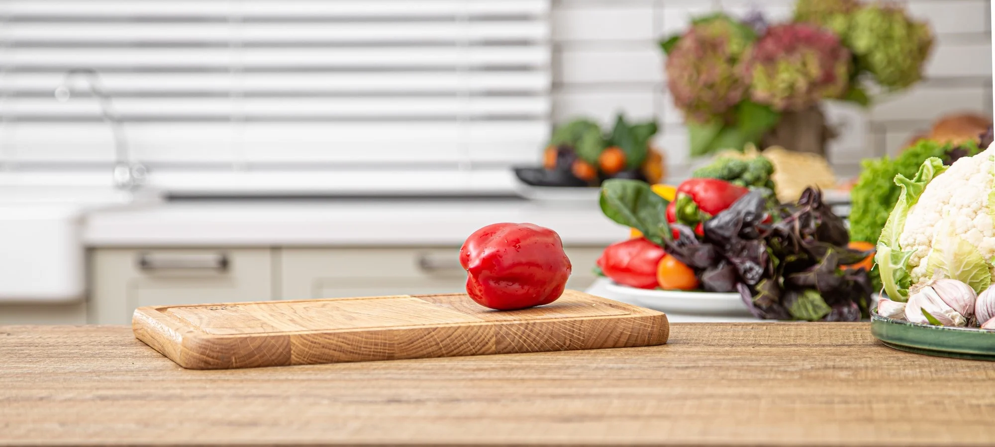 fresh-red-bell-pepper-wooden-plank-against-background-kitchen-interior
